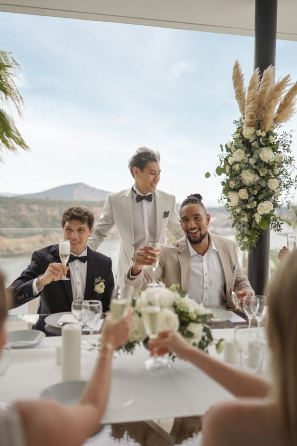 Drei Männer stoßen auf Hochzeit mit Sekt an